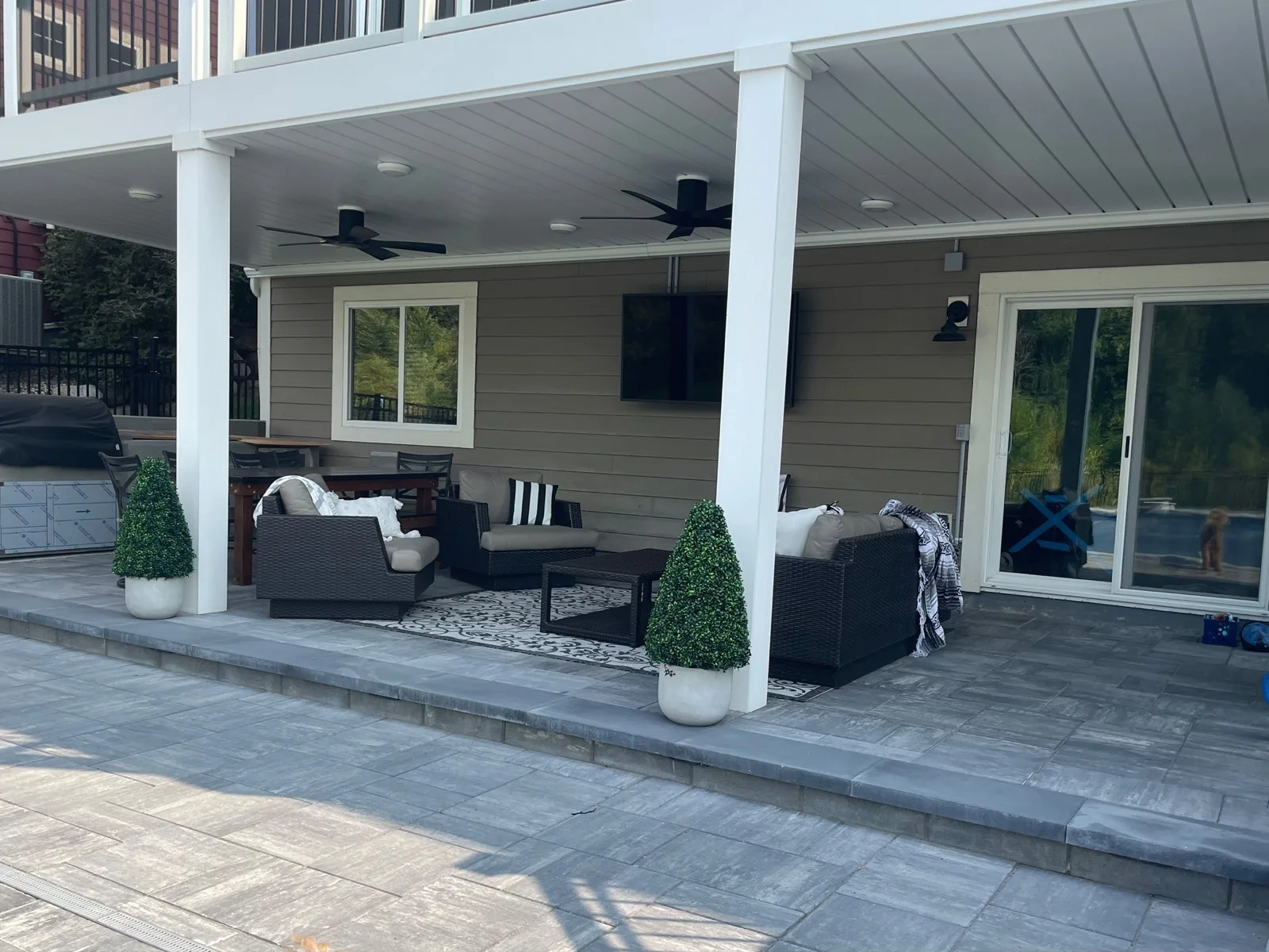 Modern patio lounge protected by a white Under Deck Oasis ceiling