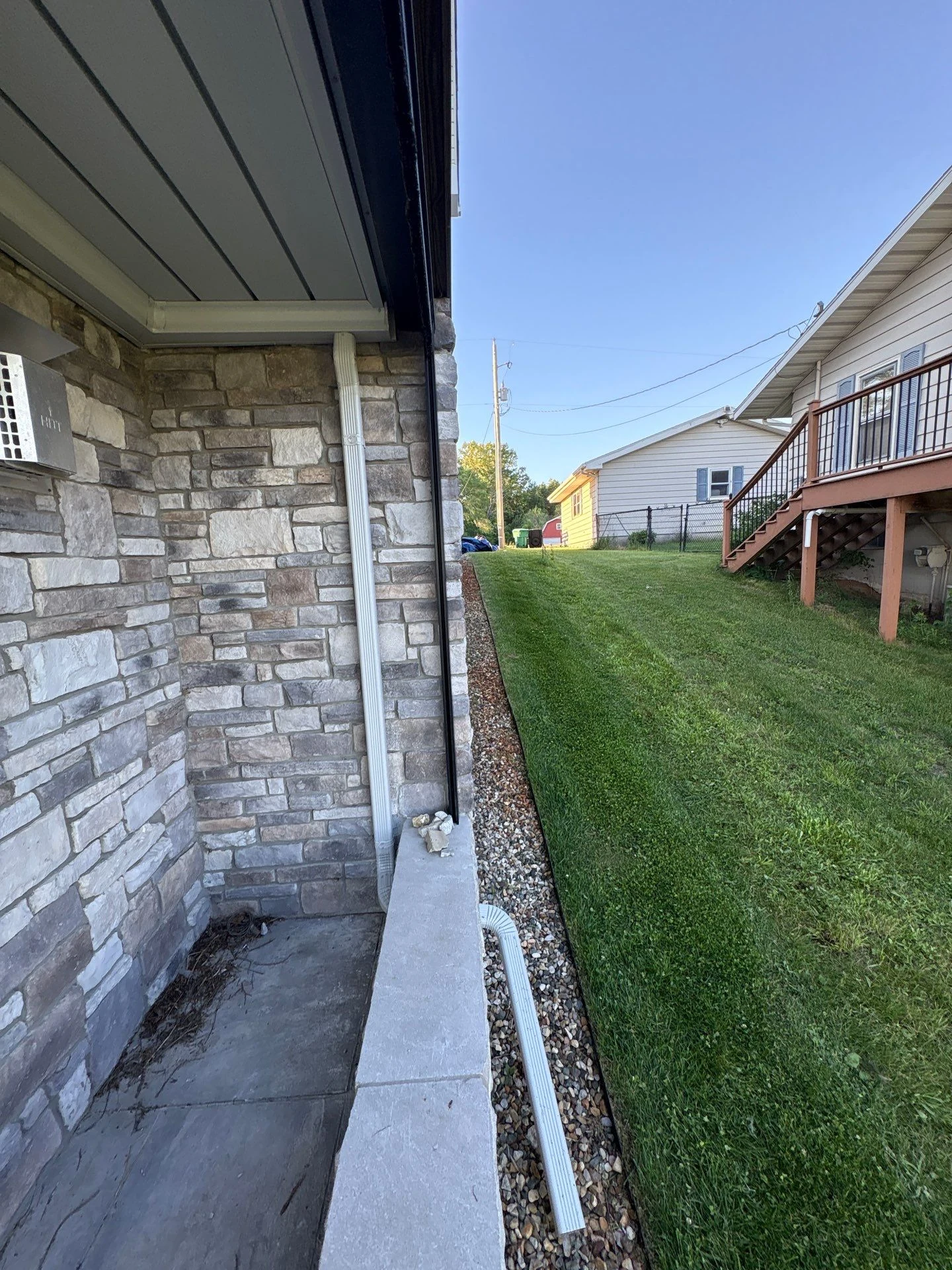 Custom downspout routing through the stone ledge
