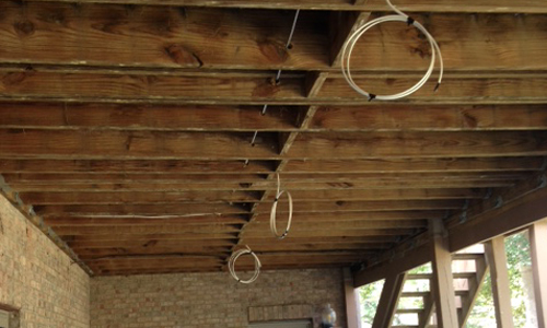 Outdoor-rated electrical lead routed through deck joists